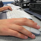Picture of person's hands on keyboard and mouse